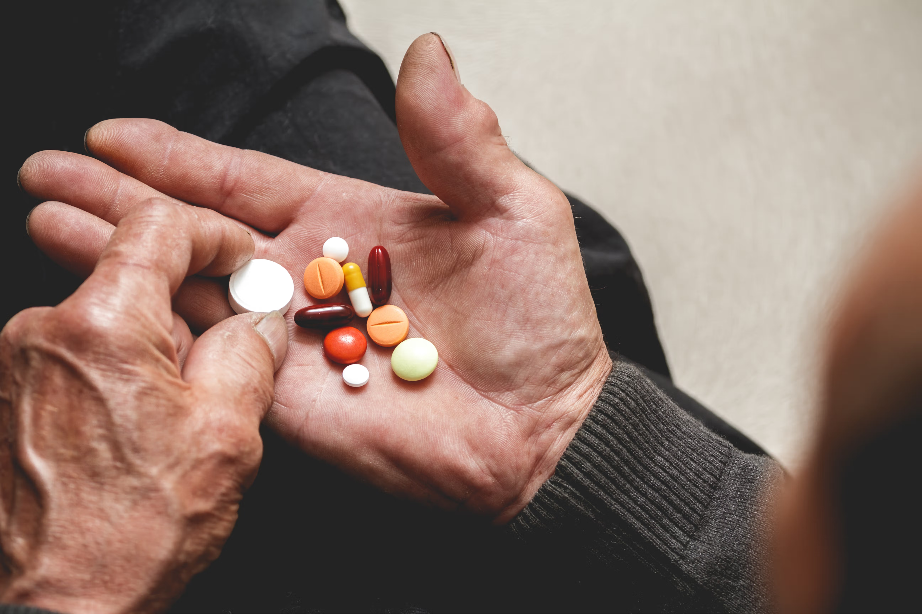 Hand with colorful pills in the palm.